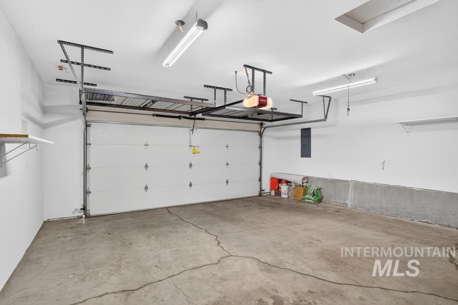 Garage featuring electric panel and a garage door opener