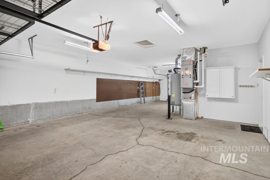 Garage featuring gas water heater and a garage door opener