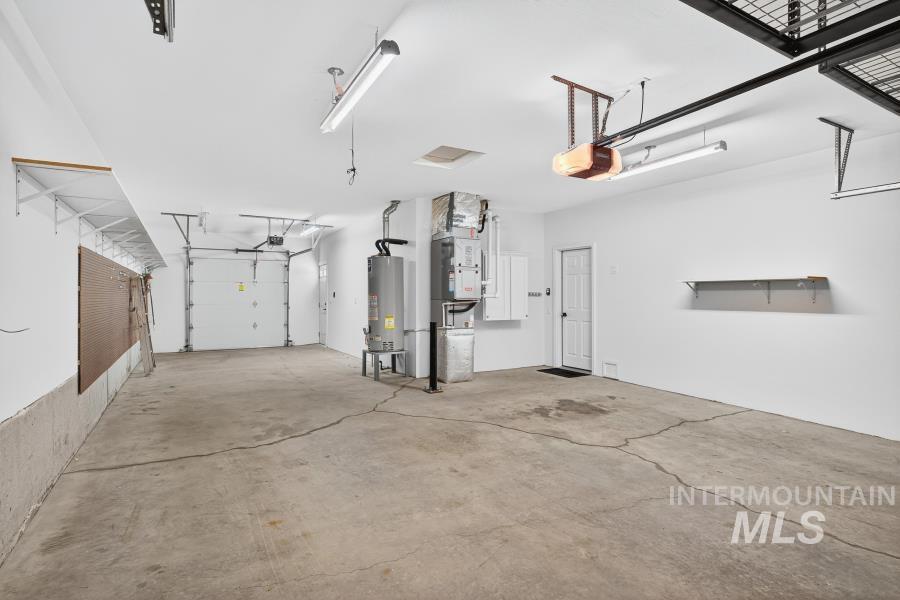 Garage with gas water heater and a garage door opener