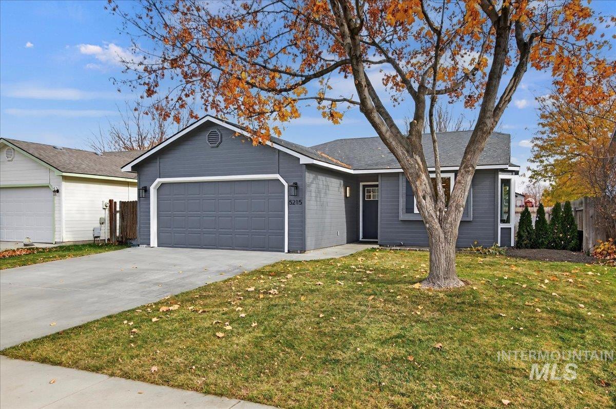Single story home featuring concrete driveway and a garage