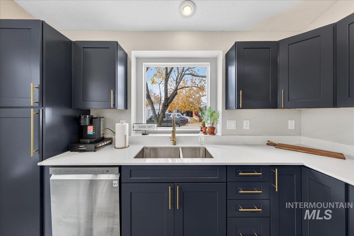 Kitchen with dishwasher and light stone countertops