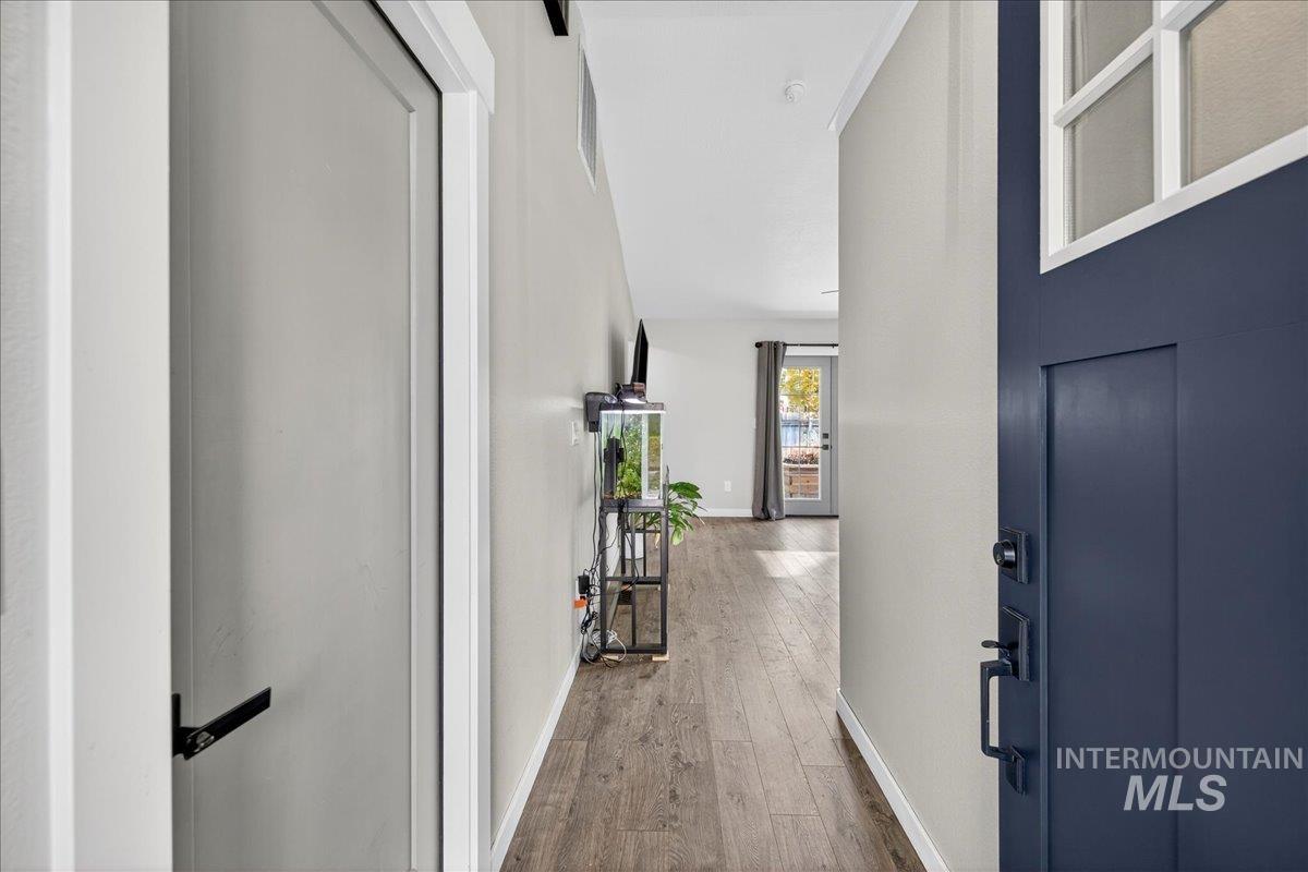 Corridor with wood-type flooring and baseboards