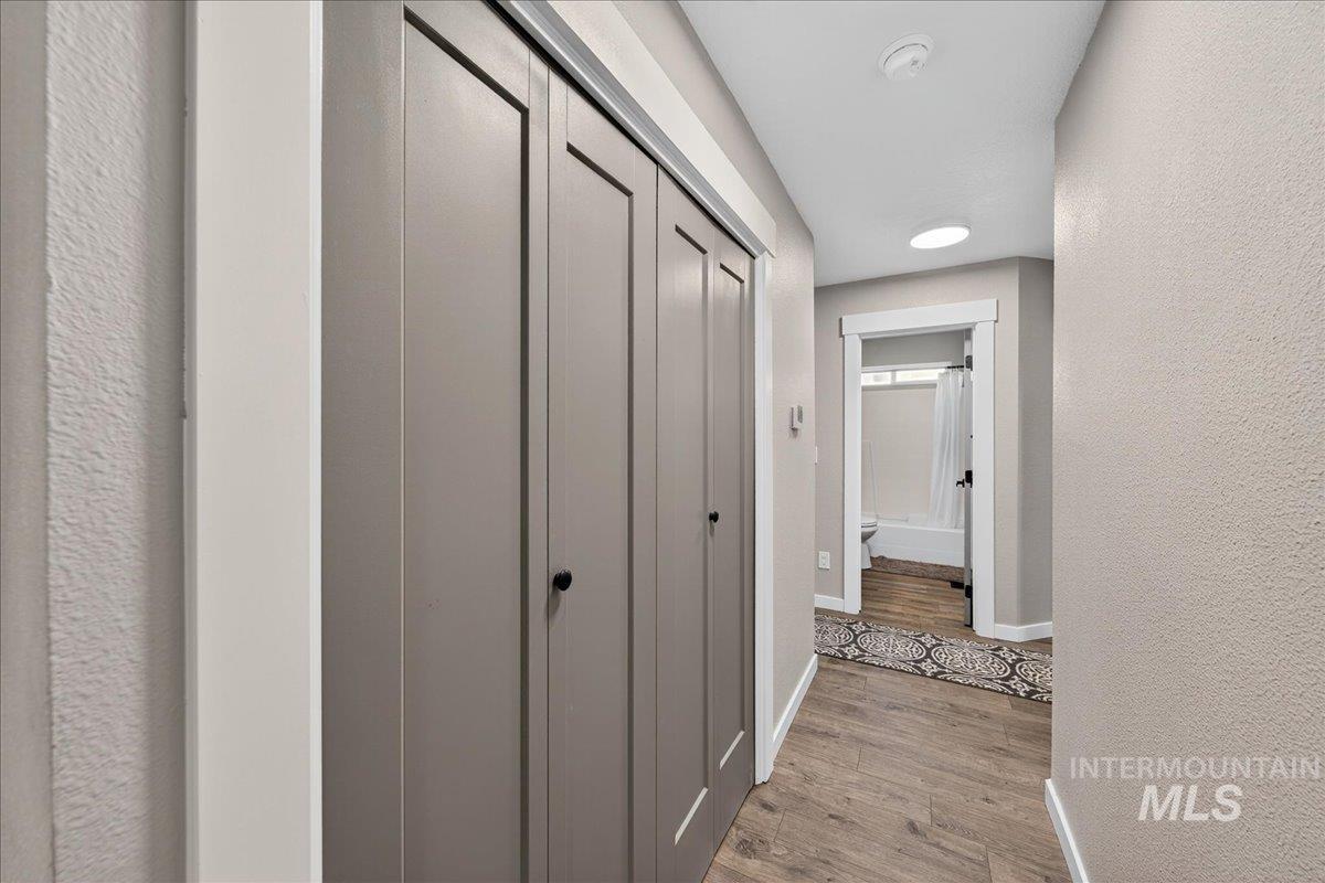 Hall with light wood finished floors and a textured wall