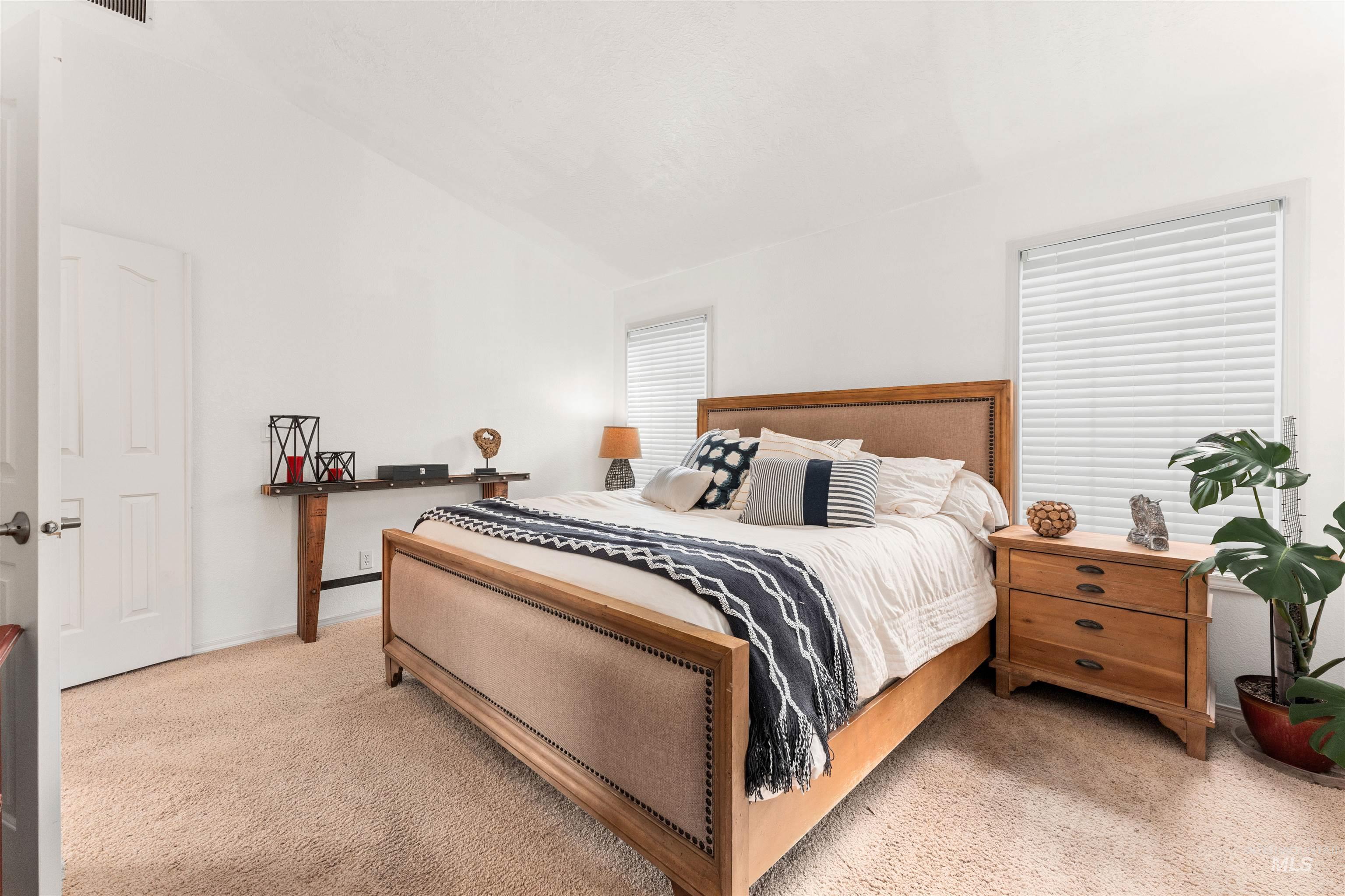 Bedroom featuring vaulted ceiling and light colored carpet