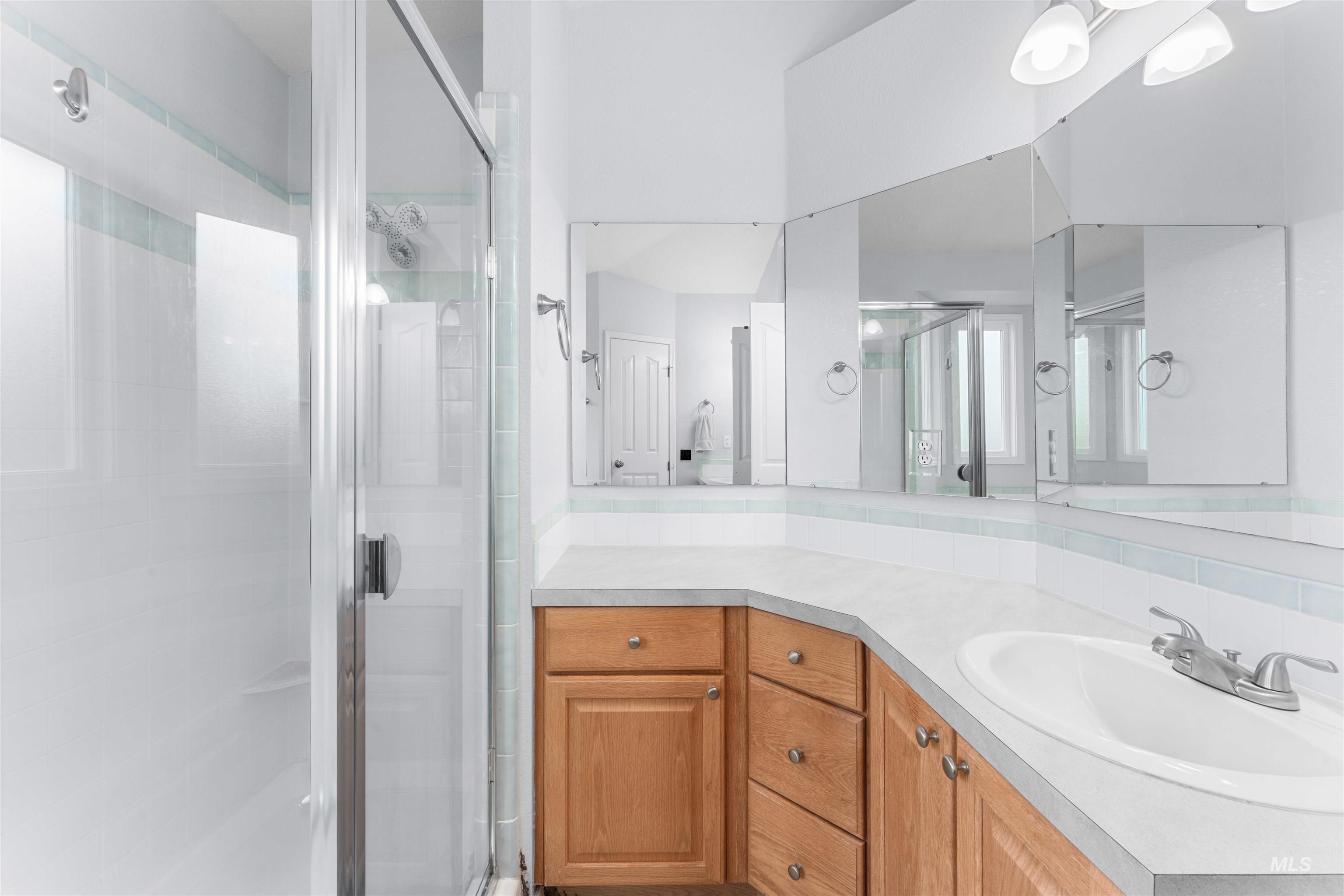 Full bathroom with vanity and a shower stall