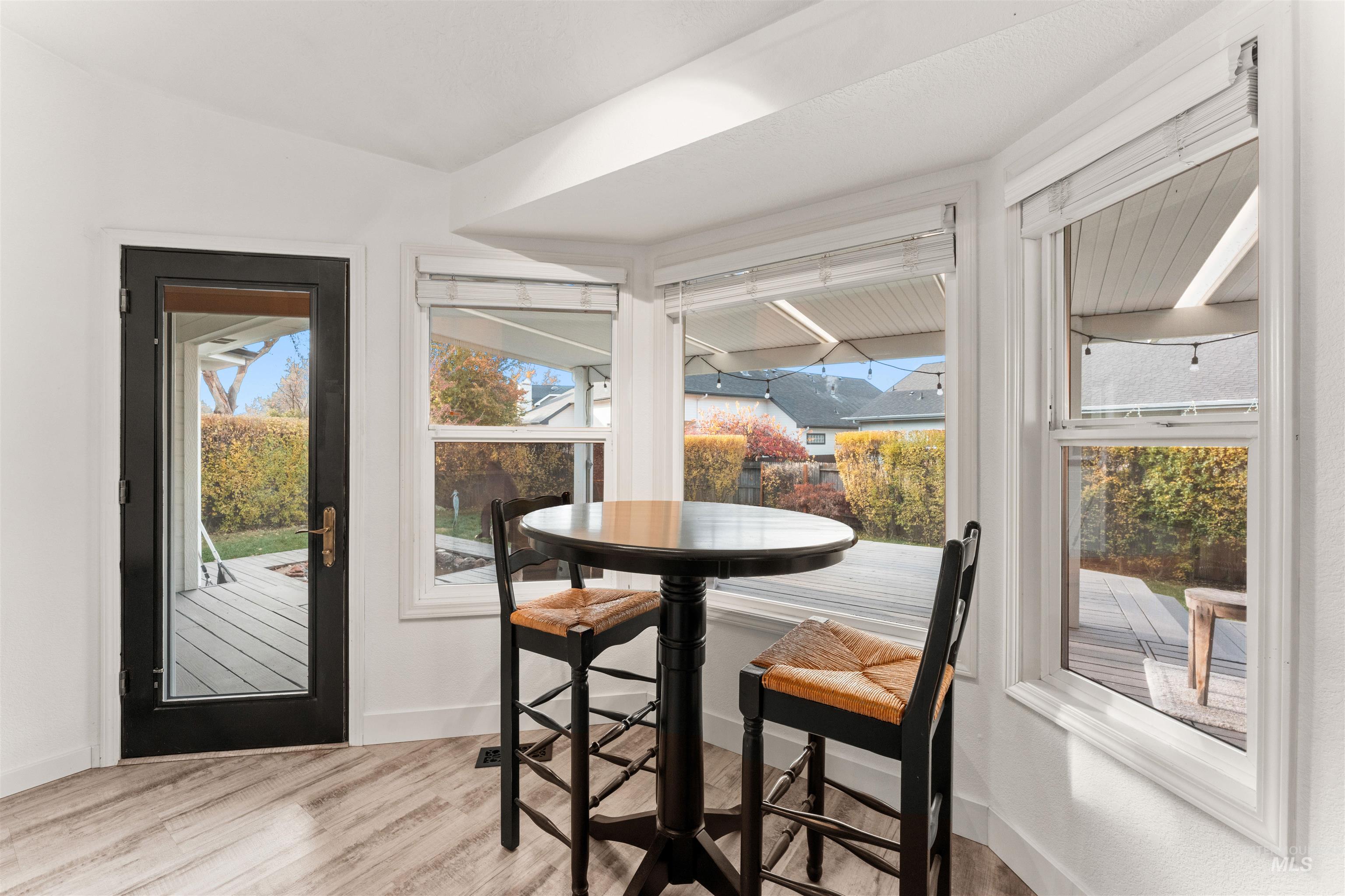Dining space with a sunroom feel and light wood-style flooring