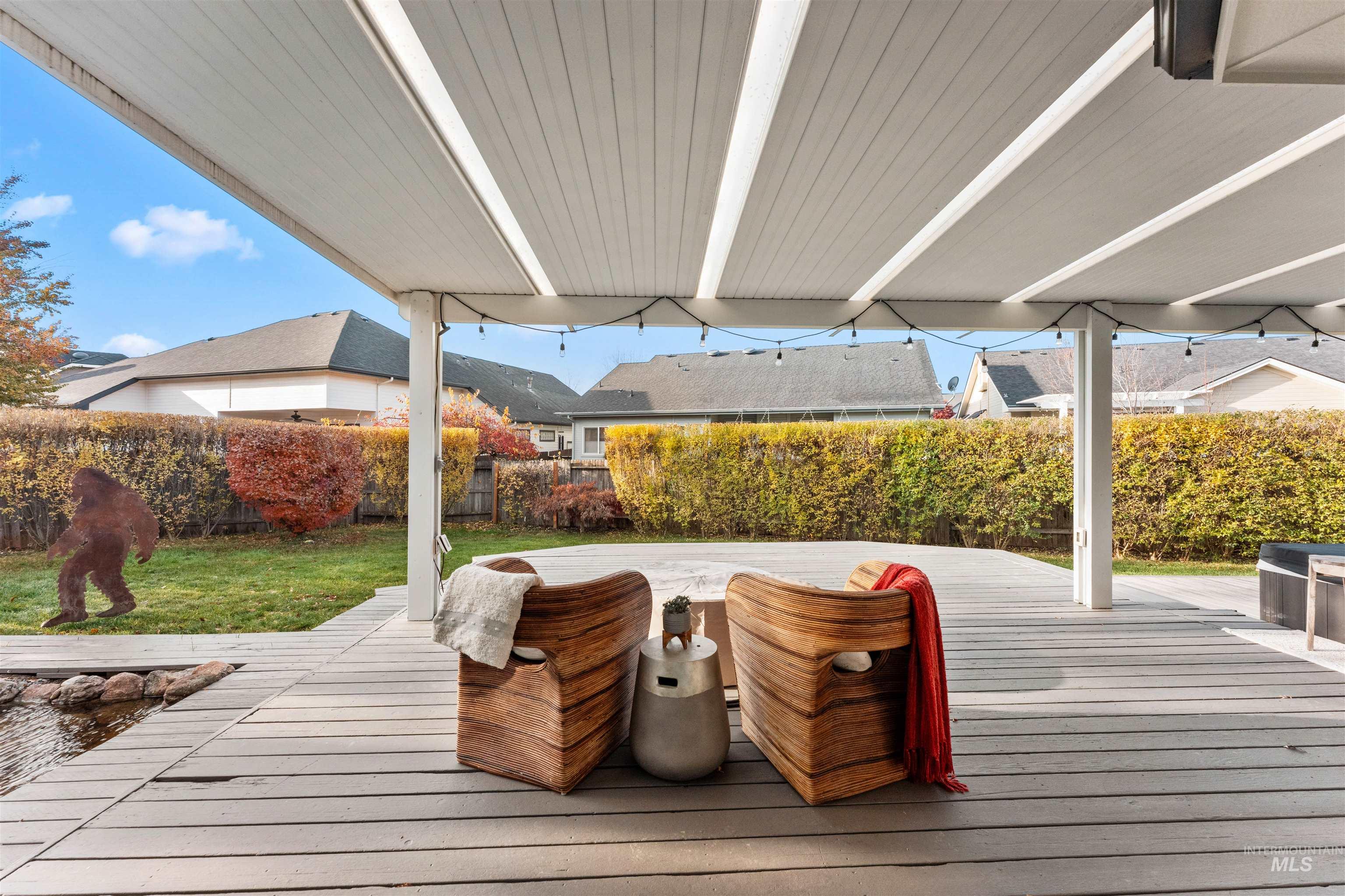 Wooden terrace with a fenced backyard