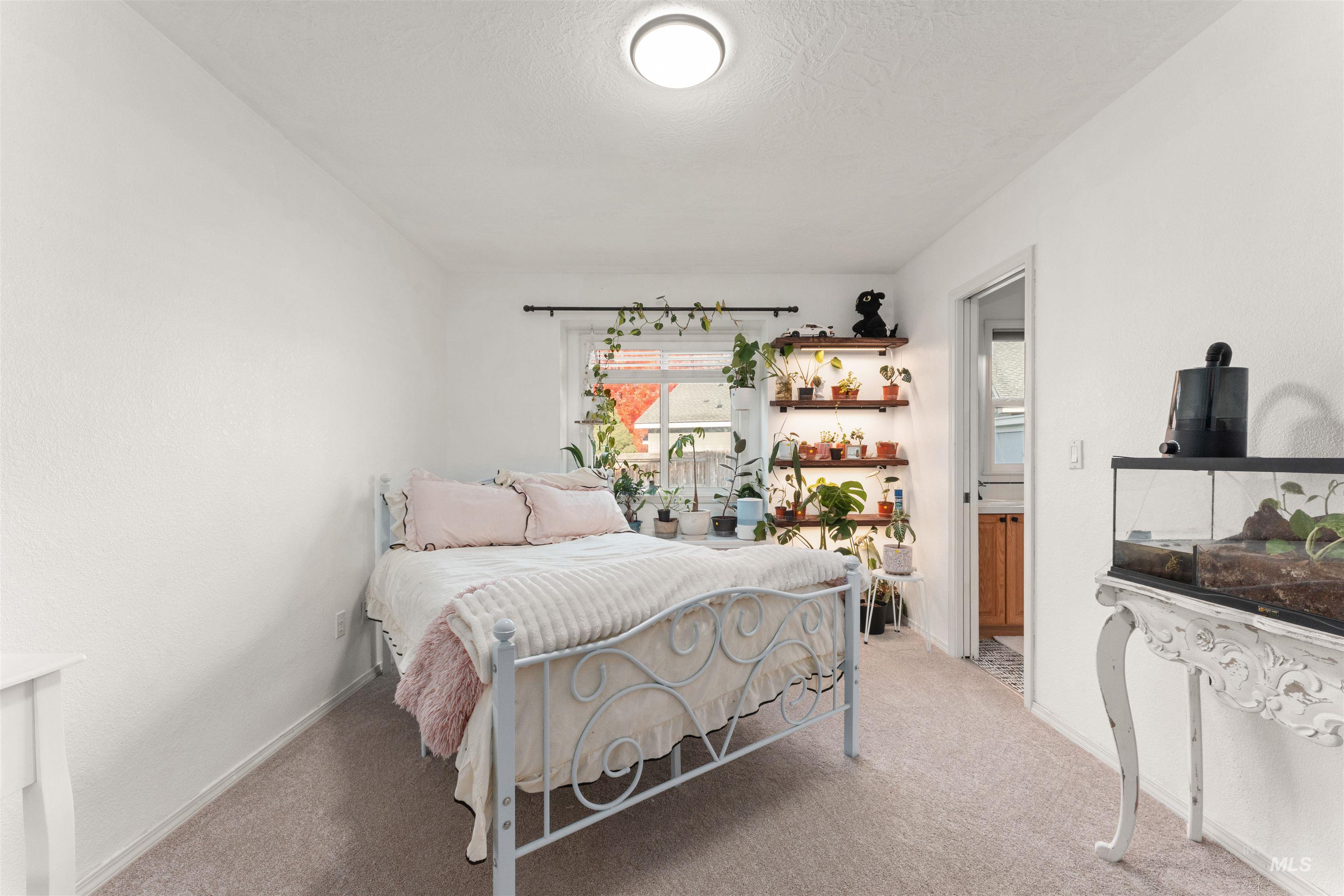 Bedroom featuring light colored carpet and a textured ceiling