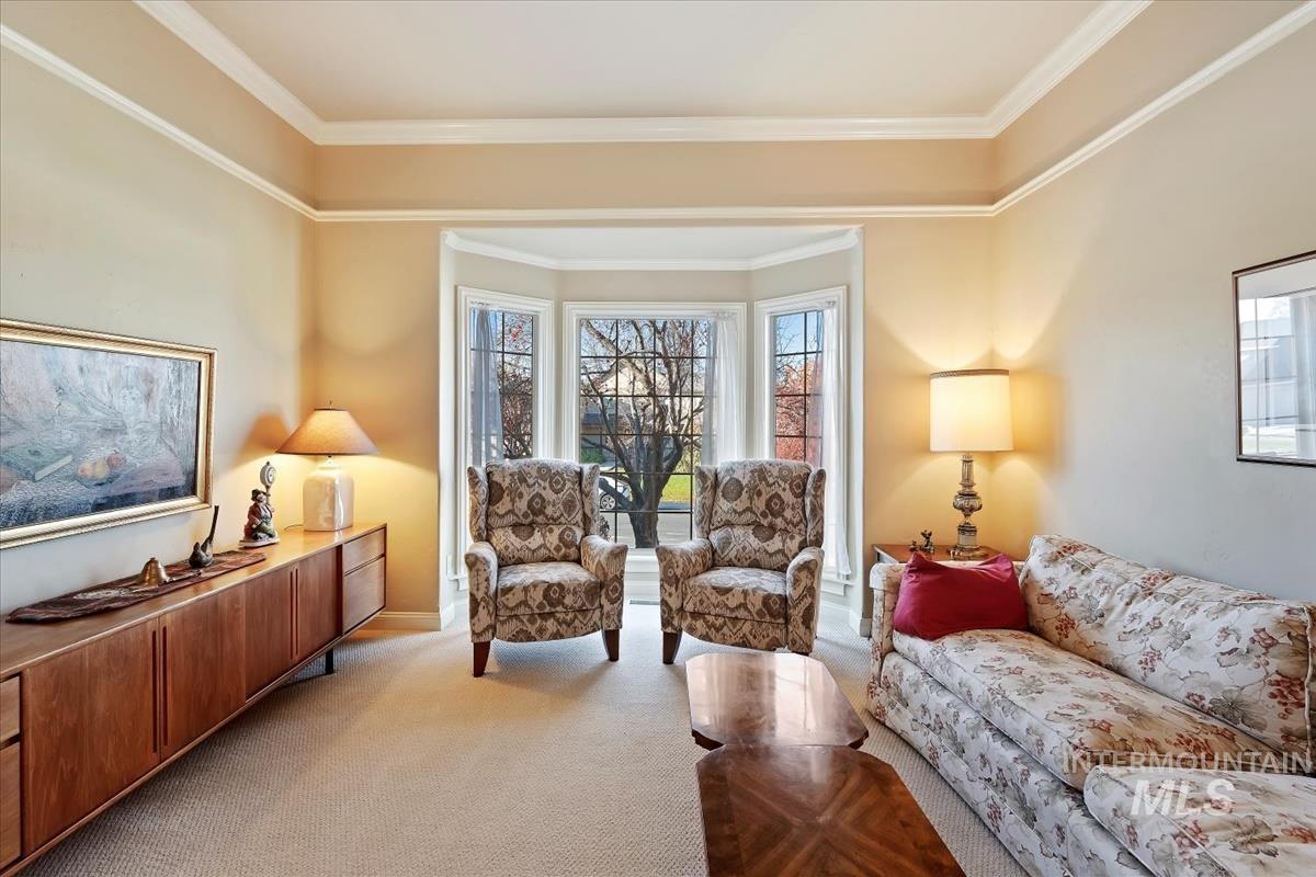 Living area featuring light carpet and ornamental molding