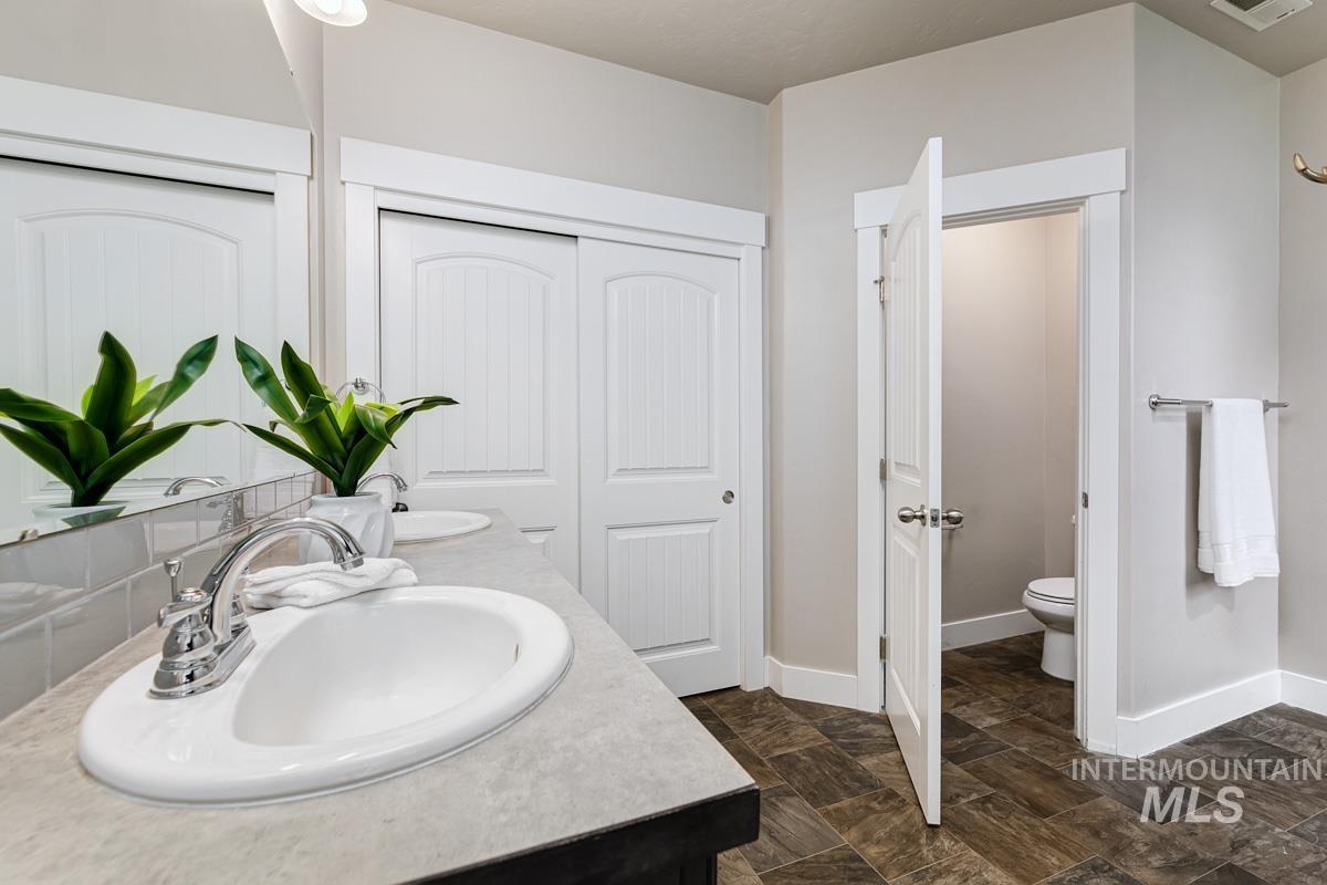 Full bathroom with toilet and double vanity