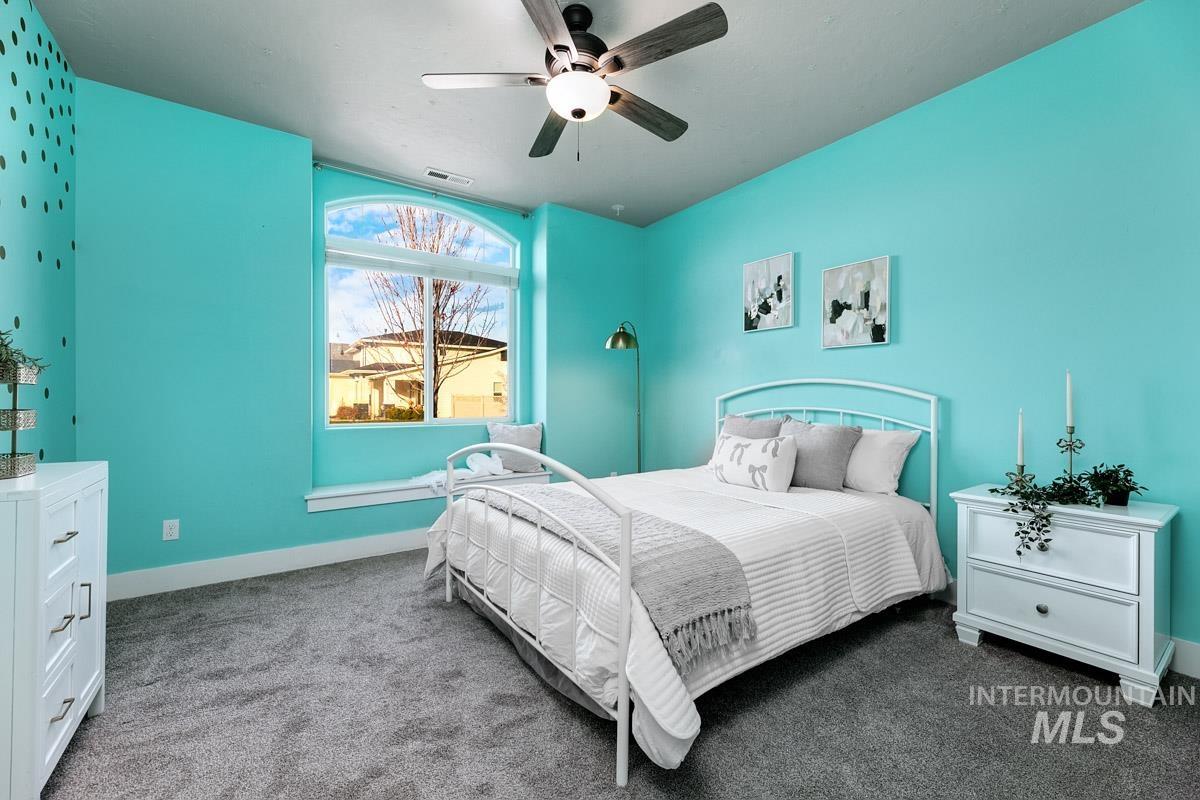 Carpeted bedroom featuring baseboards and ceiling fan