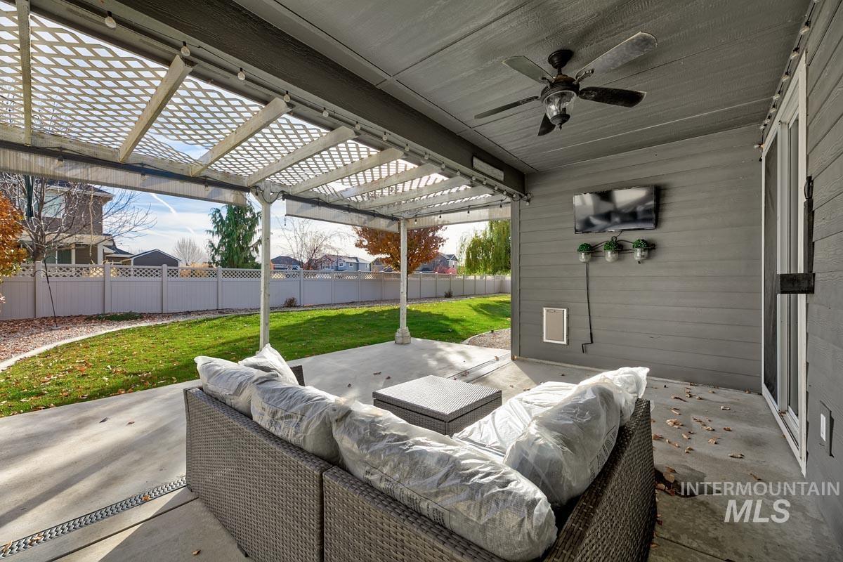 Fenced backyard featuring a patio area, a pergola, and a ceiling fan