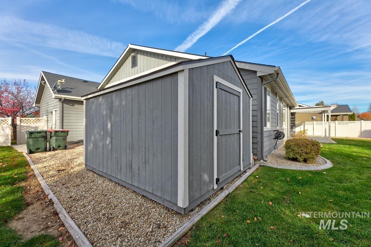 View of side of home featuring a storage shed