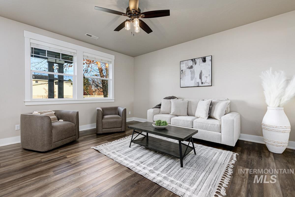 Living room featuring dark wood-type flooring and ceiling fan
