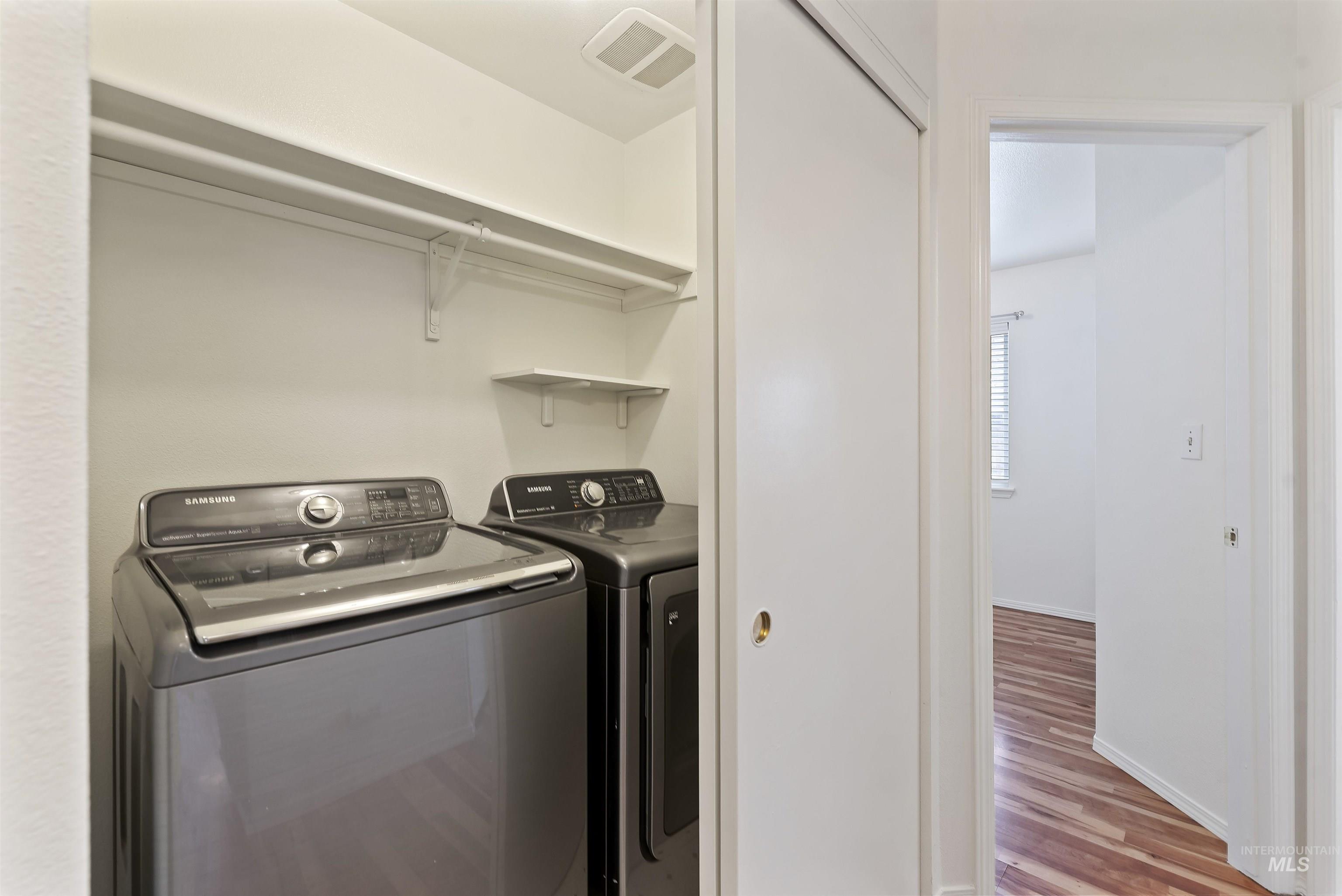 Laundry room featuring washer and dryer and light wood-style flooring
