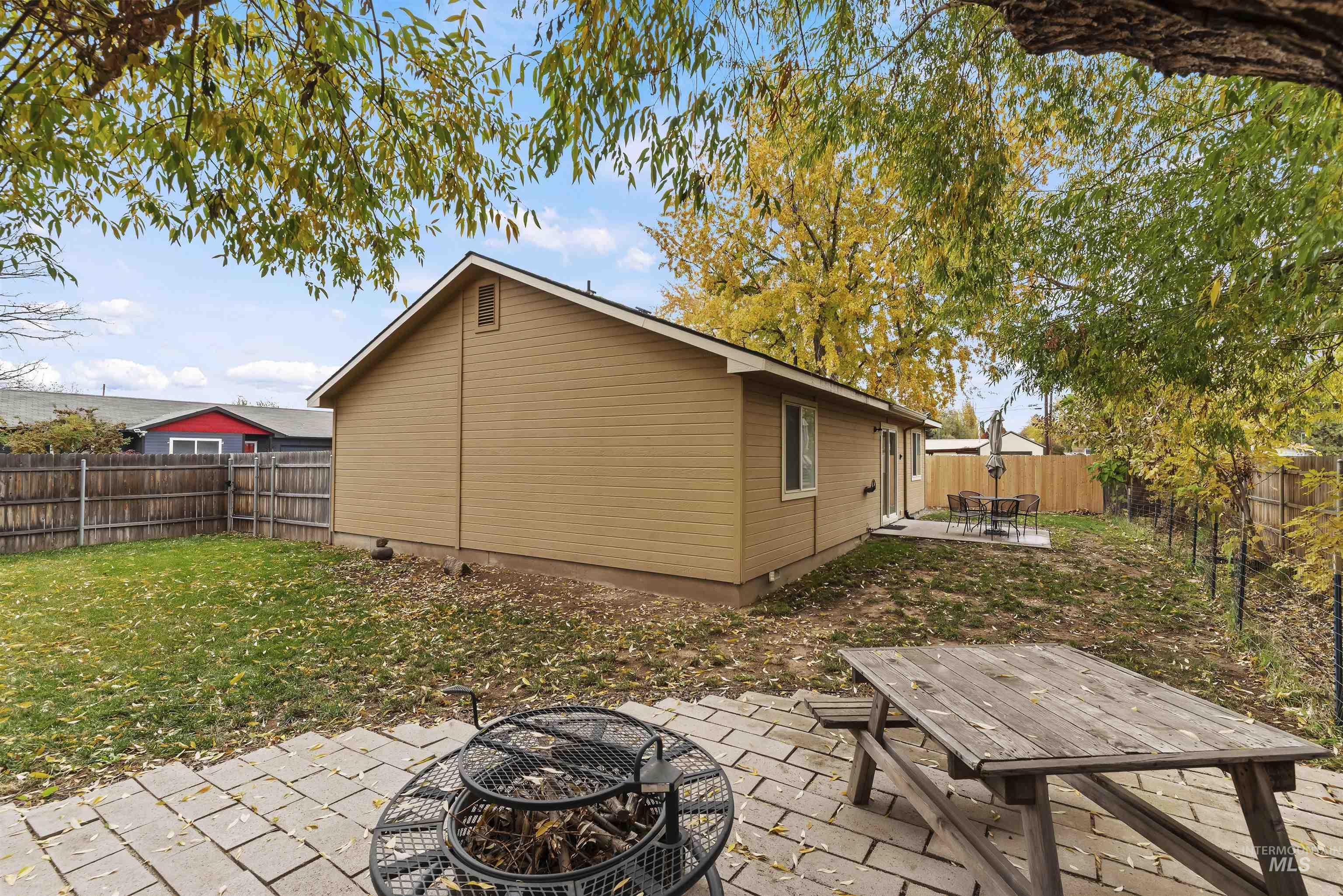 Rear view of house featuring a patio area, a fenced backyard, an outdoor fire pit, and outdoor dining space