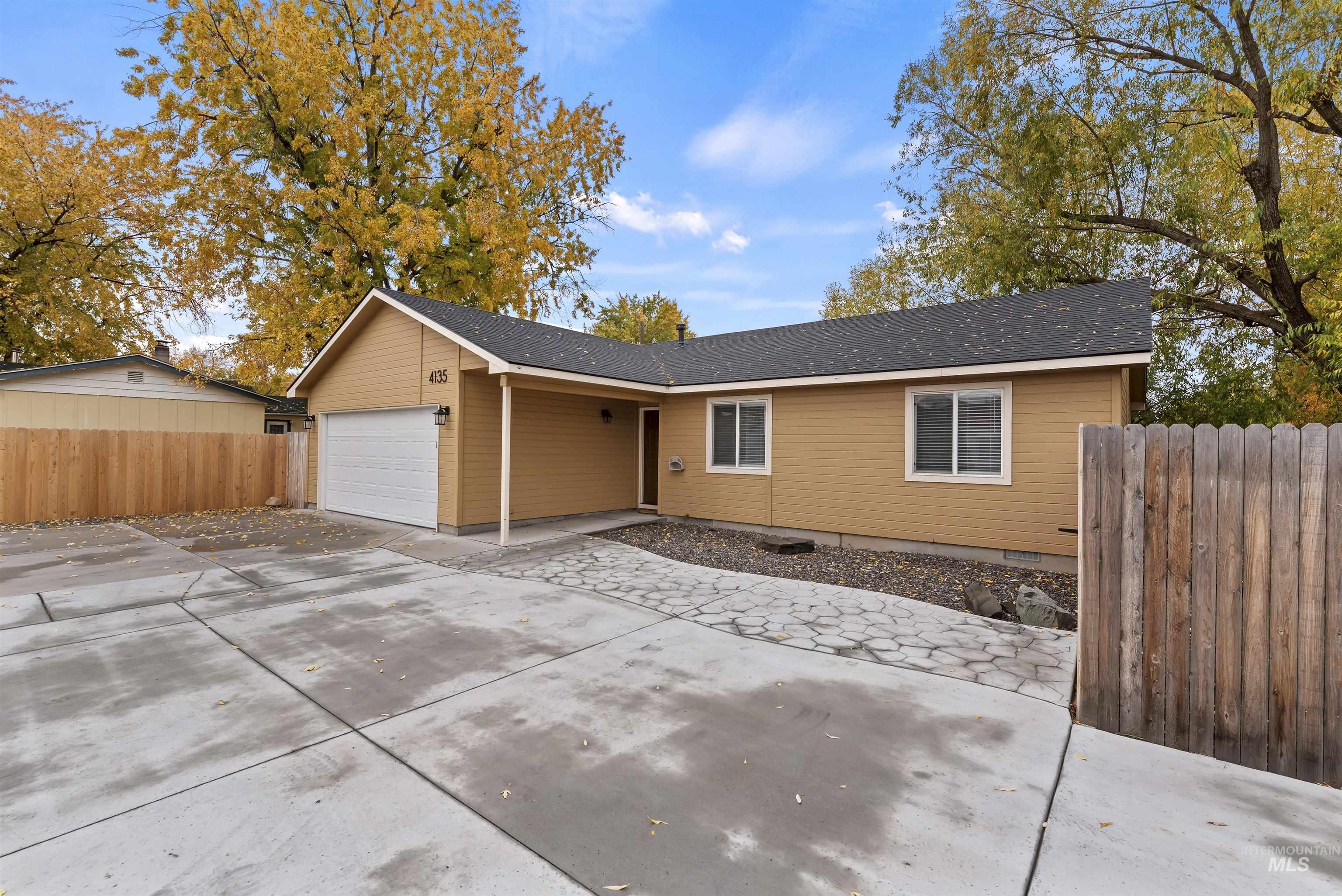 Ranch-style house featuring driveway, an attached garage, and a shingled roof