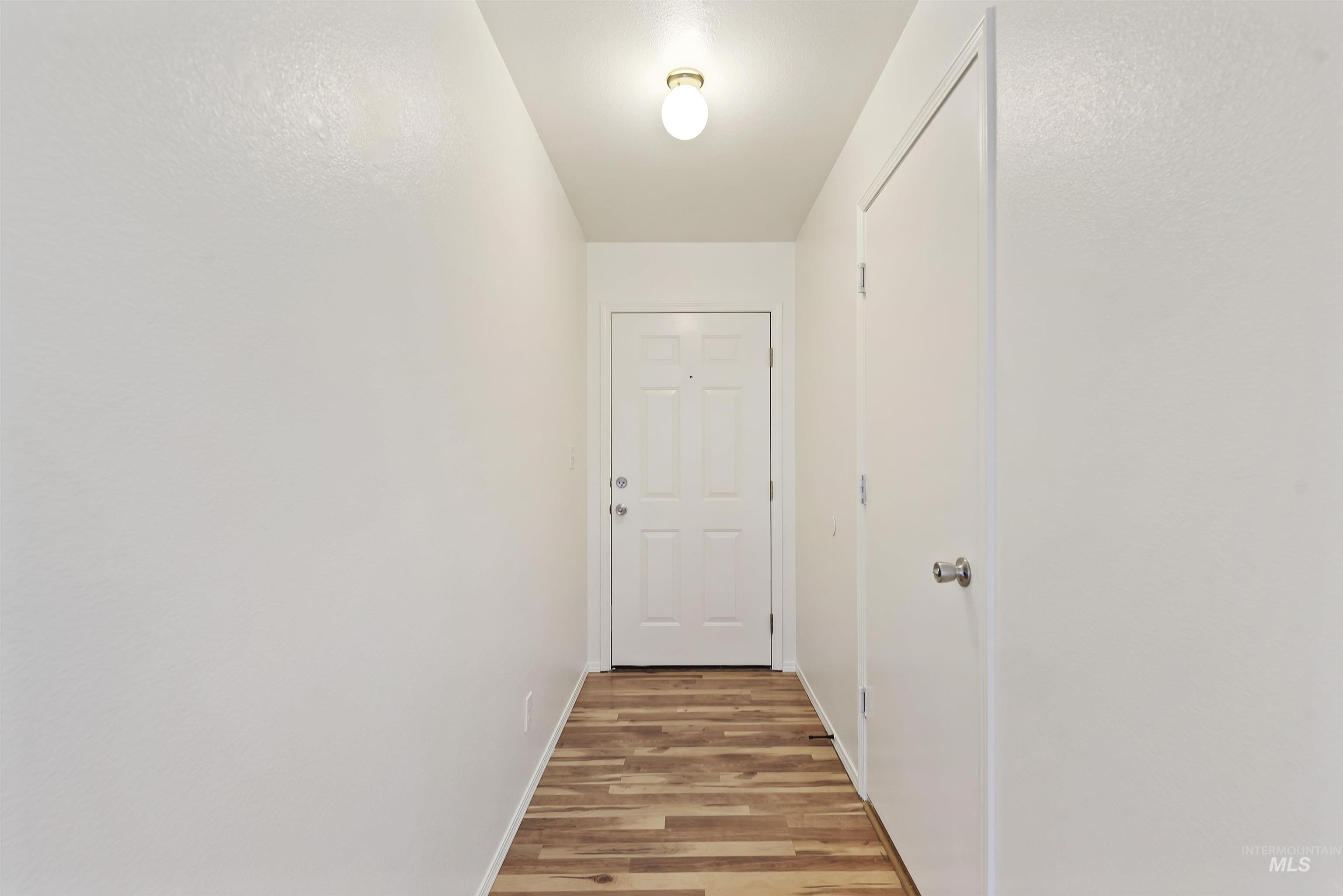Hall with light wood-type flooring and baseboards