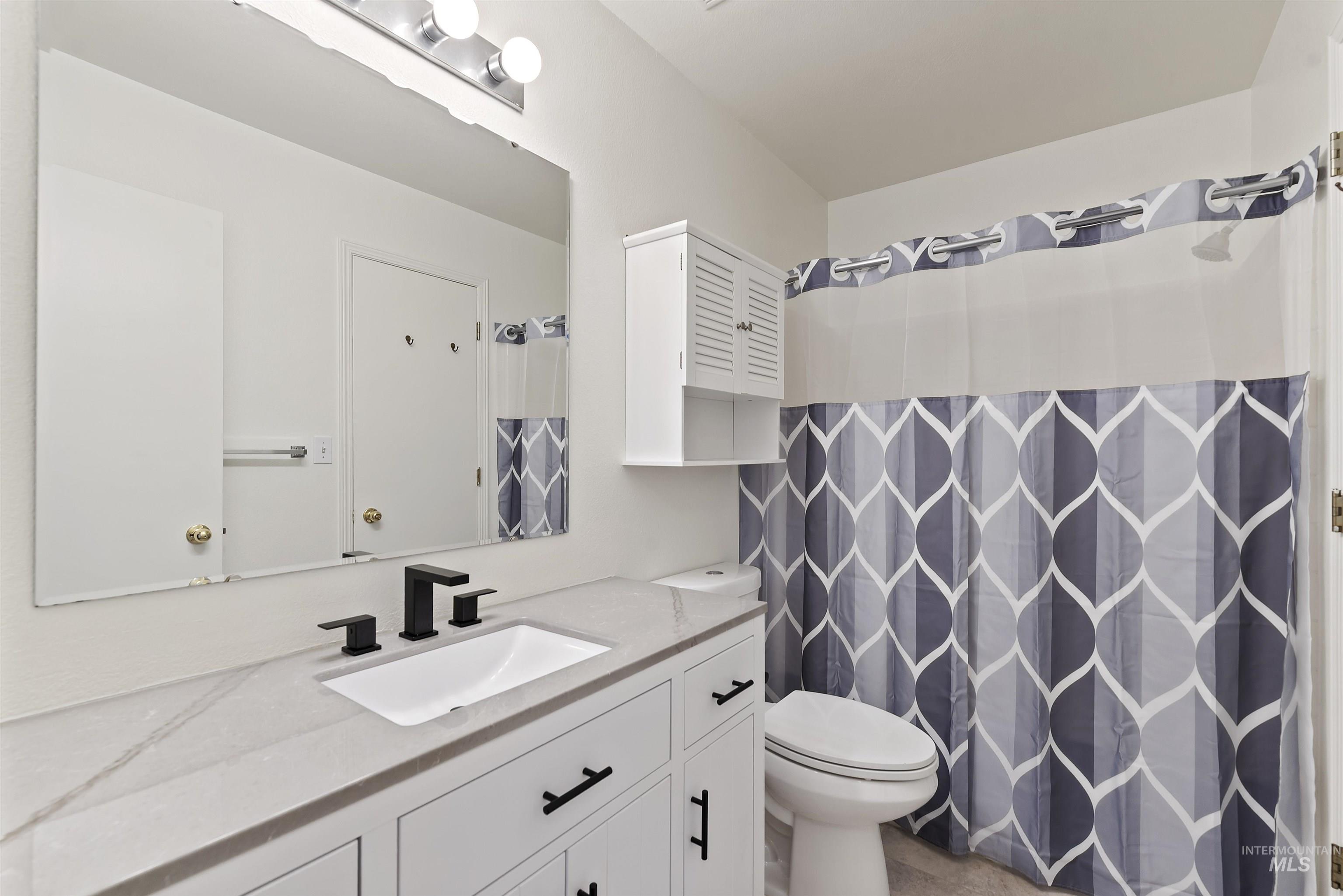 Bathroom with vanity and curtained shower