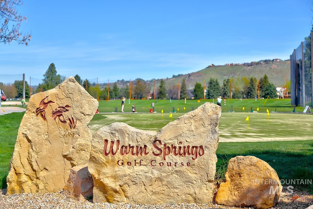 Community / neighborhood sign featuring a lawn, a mountain view, and view of wooded area