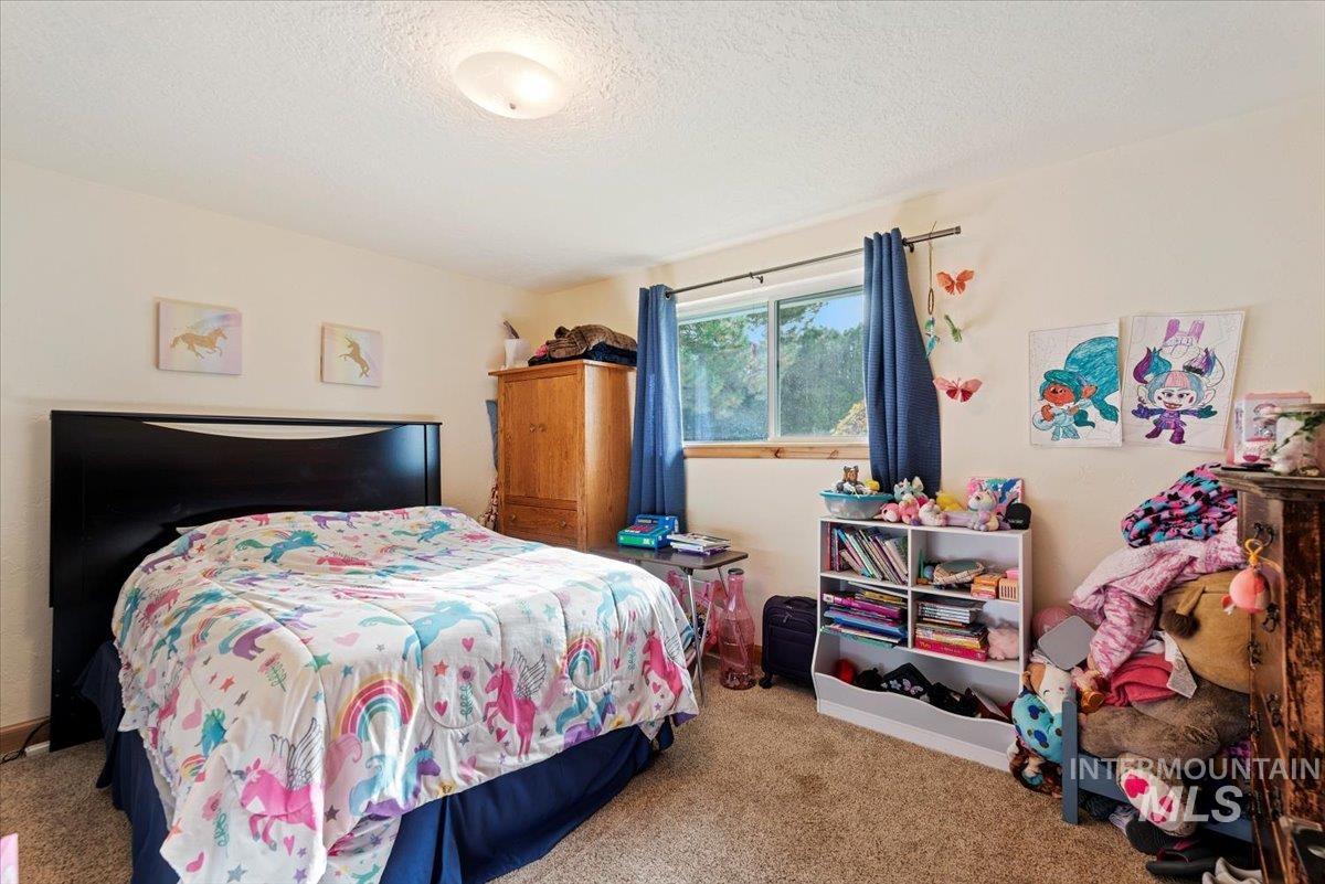 Bedroom featuring carpet flooring and a textured ceiling