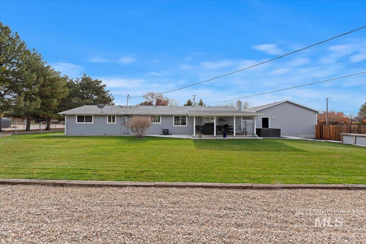 Rear view of property featuring a patio and a hot tub