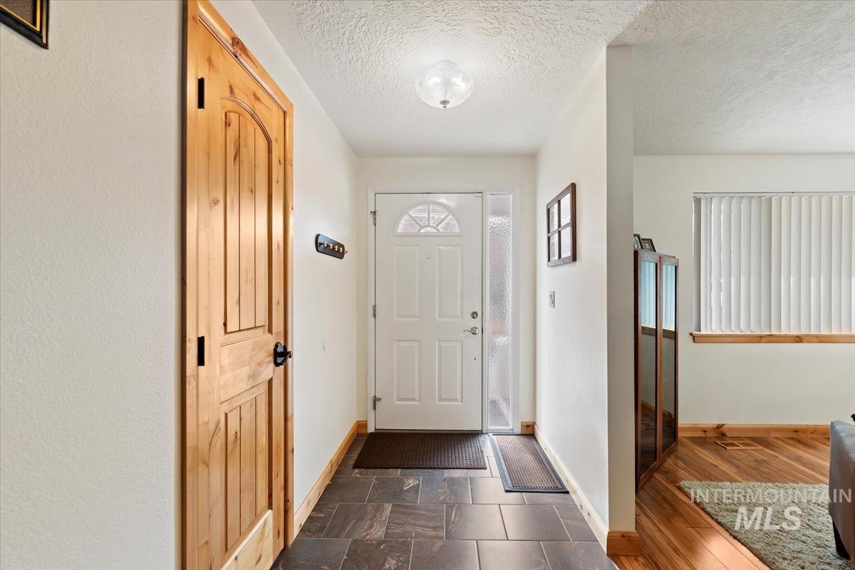 Foyer with baseboards and a textured ceiling
