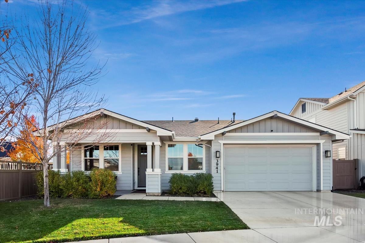 View of front of property with board and batten siding, concrete driveway, a shingled roof, and an attached garage