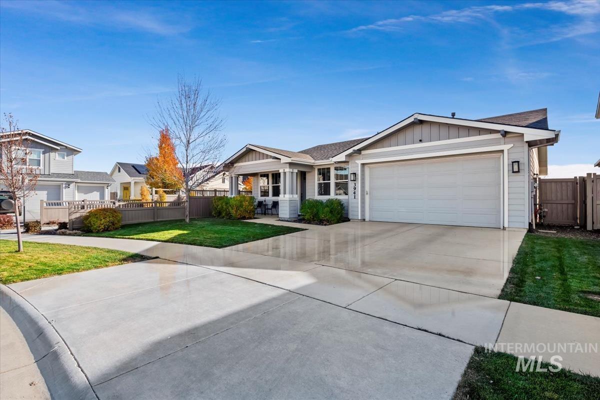 Ranch-style house with board and batten siding, driveway, an attached garage, and a shingled roof