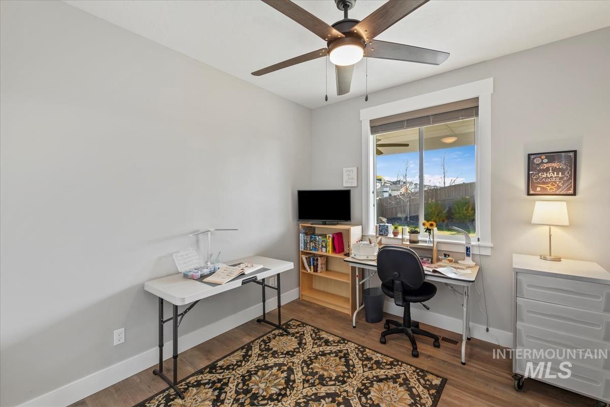 Office area with dark wood-type flooring and baseboards
