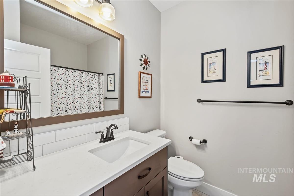 Full bath with a shower with curtain and vanity