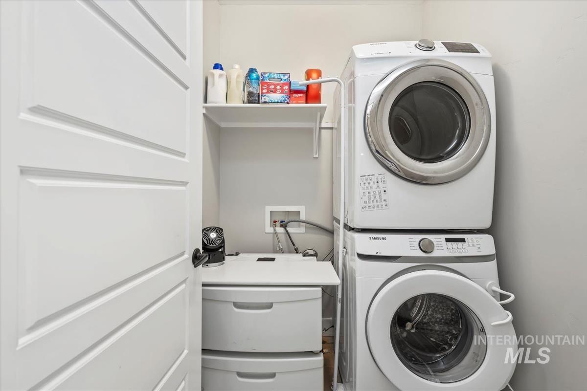 Laundry room featuring stacked washing machine and dryer