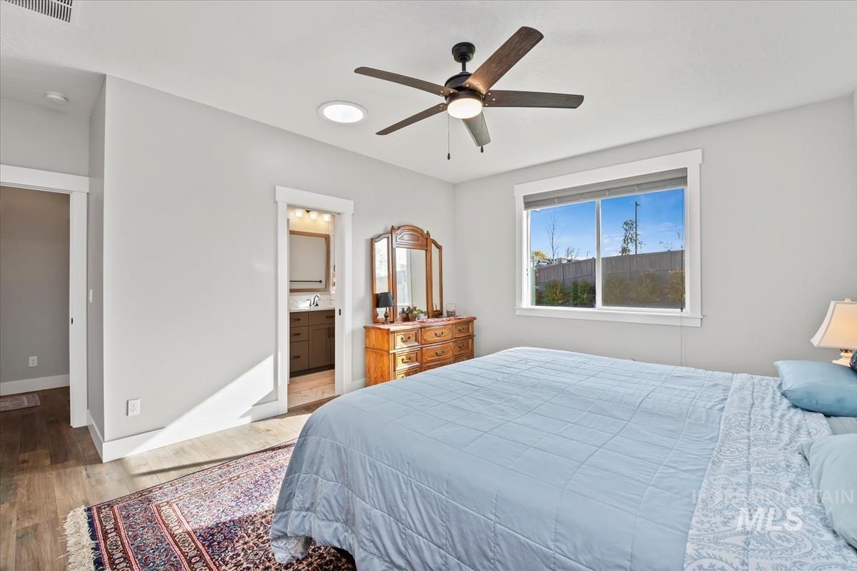 Bedroom featuring light wood-style floors, ceiling fan, and connected bathroom