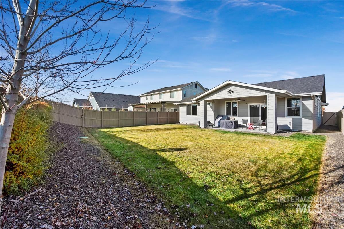 Back of house with a fenced backyard, a ceiling fan, and a patio