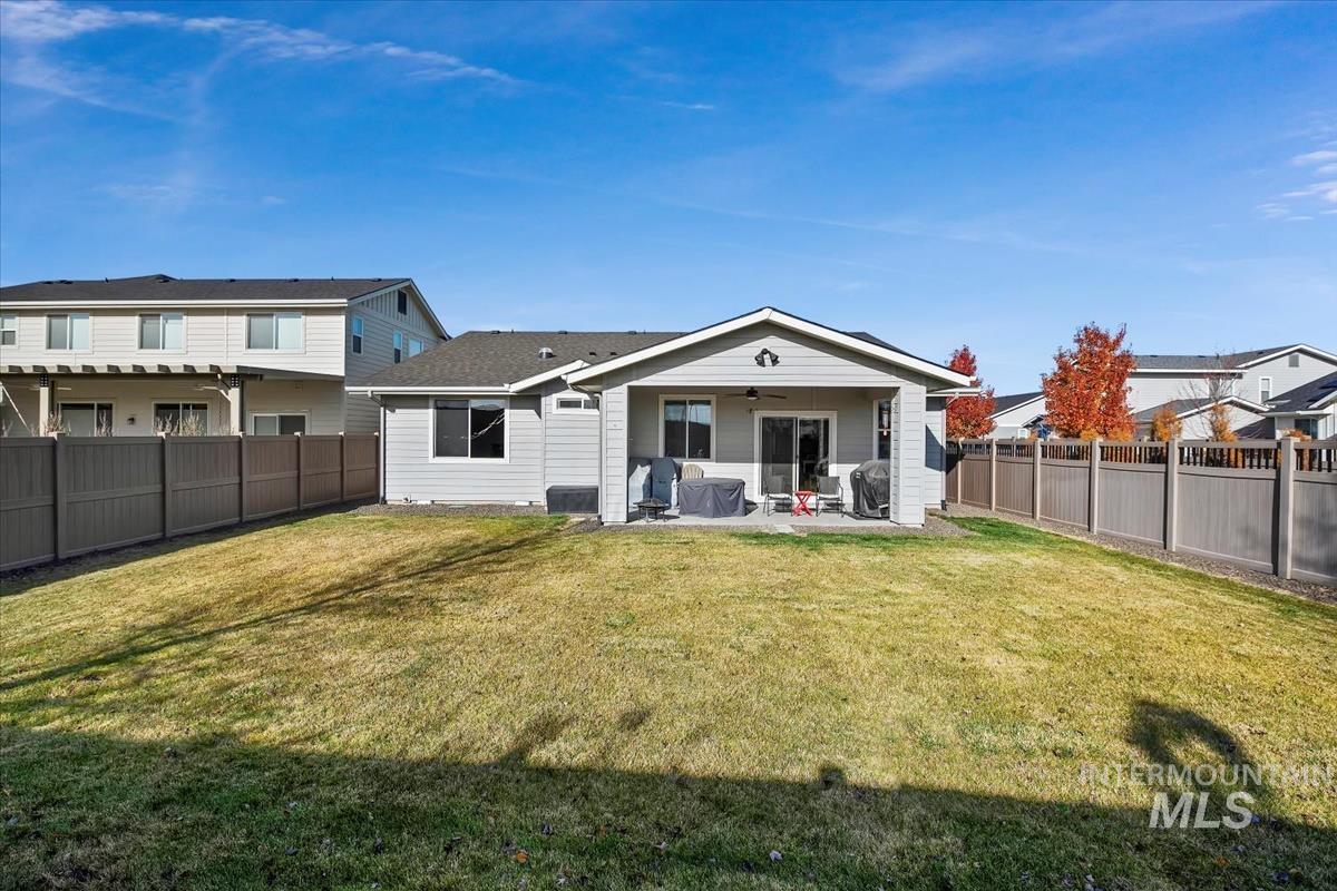 Rear view of property featuring a patio, ceiling fan, and a fenced backyard