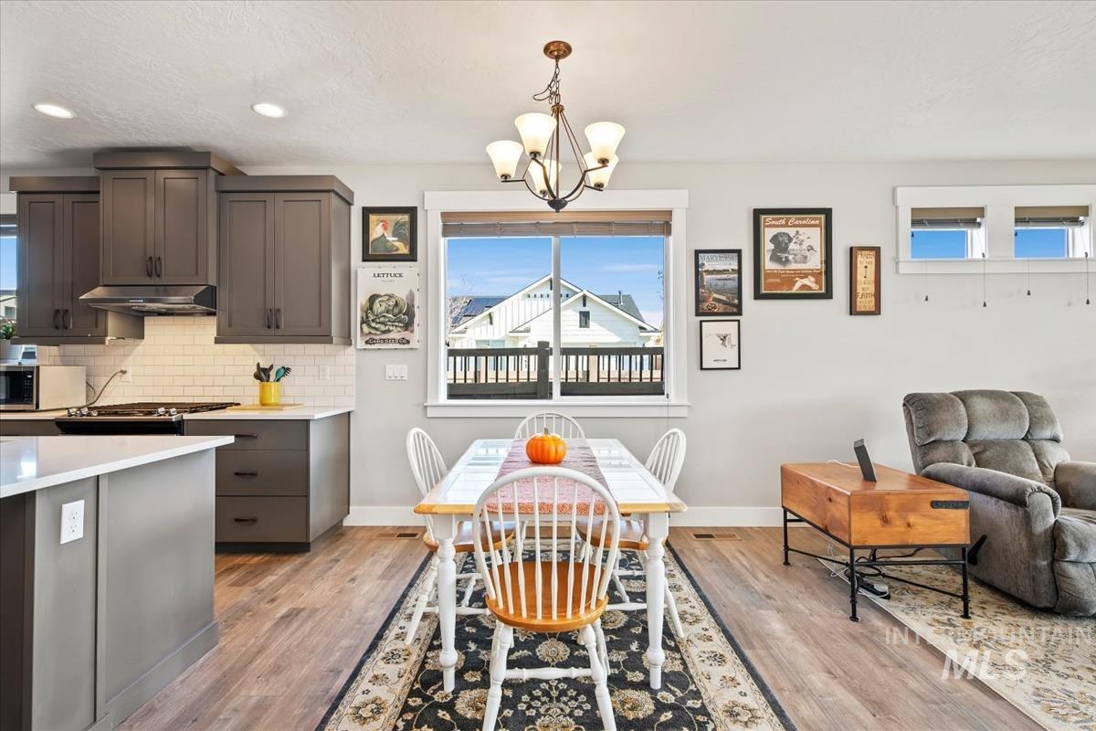 Dining space with plenty of natural light, light wood-style floors, a chandelier, and recessed lighting