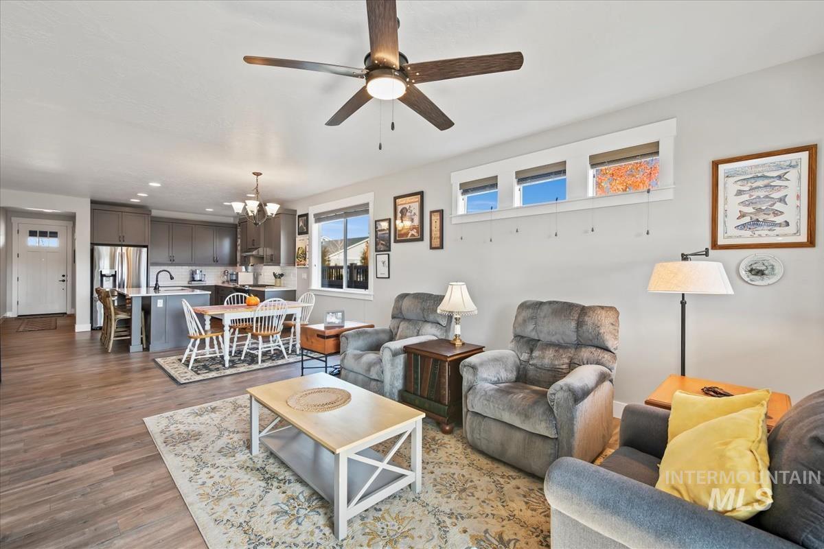 Living area with a chandelier, dark wood-style floors, ceiling fan, and recessed lighting