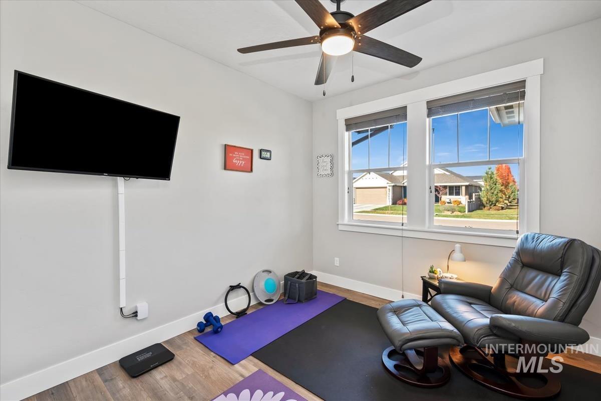 Exercise room with wood finished floors and ceiling fan