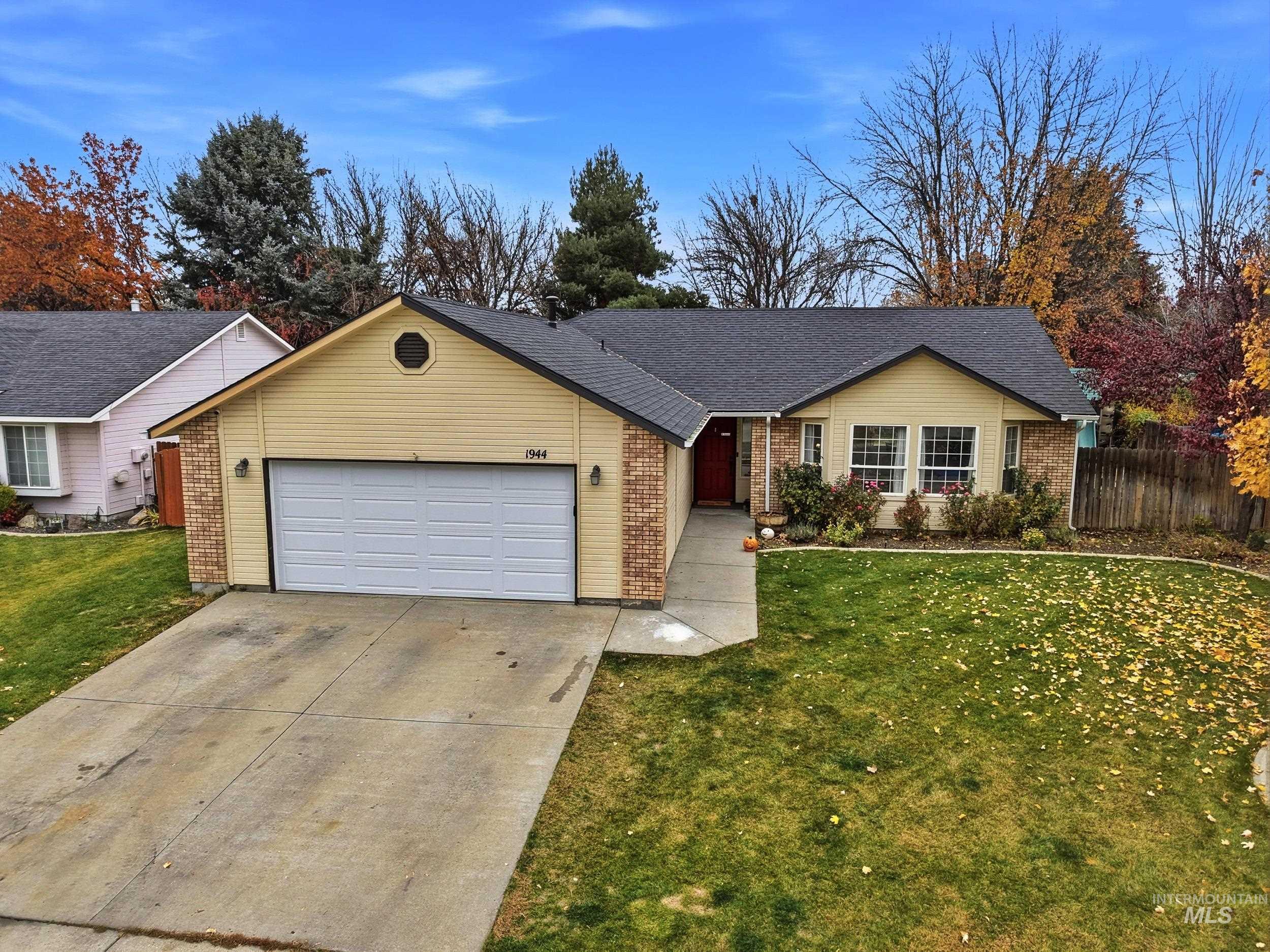 Ranch-style home with concrete driveway, a garage, brick siding, and roof with shingles