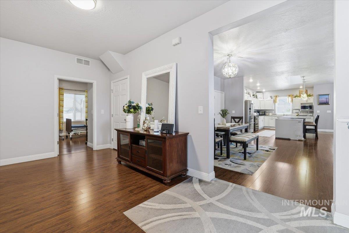 Hallway with dark wood-style floors, a chandelier, and a textured ceiling