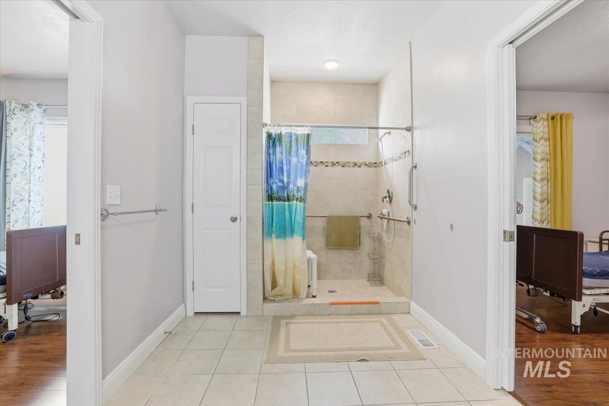 Full bath with a stall shower and light tile patterned floors