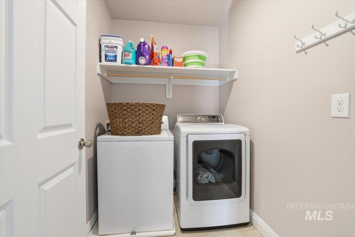 Laundry area with independent washer and dryer and baseboards - Upper level