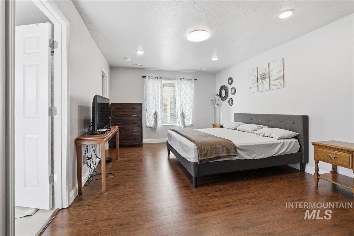 Bedroom featuring dark wood finished floors, recessed lighting, and a textured ceiling