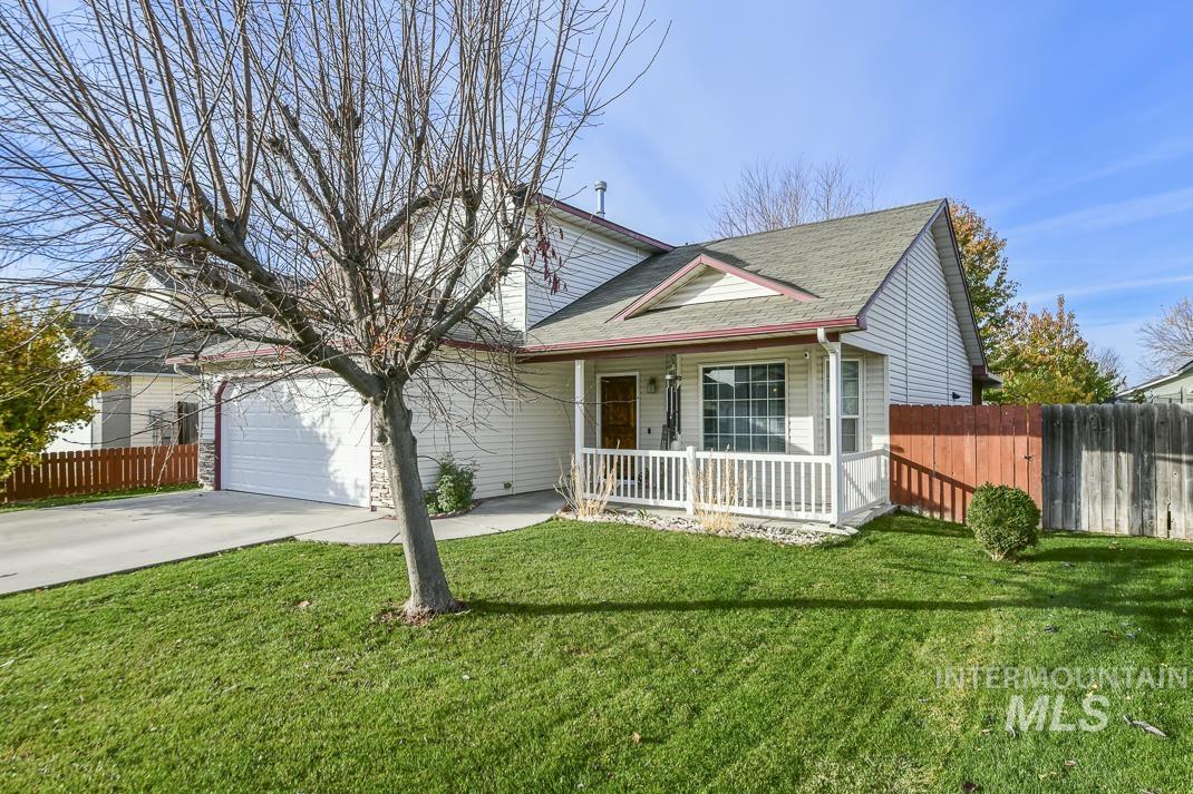 View of front of house featuring concrete driveway, a shingled roof, covered porch, and an attached garage