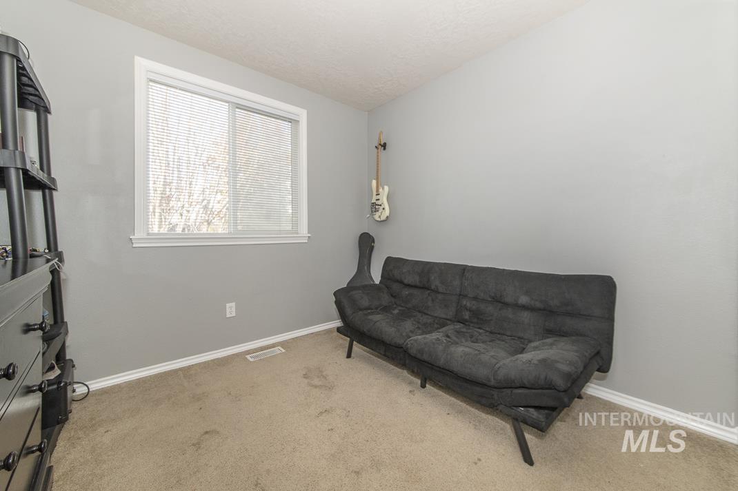 Living area with carpet and a textured ceiling