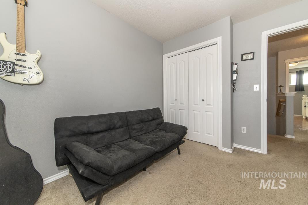 Living area with carpet flooring and a textured ceiling