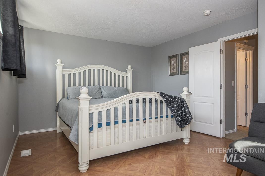 Bedroom with a textured ceiling and baseboards