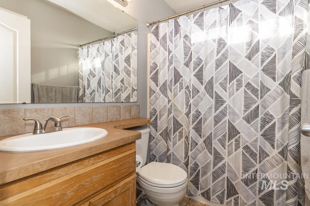 Full bath with vanity, a shower with shower curtain, and backsplash