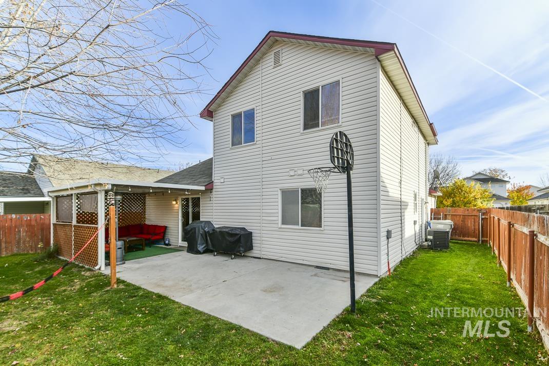 Rear view of house featuring a fenced backyard and a patio area