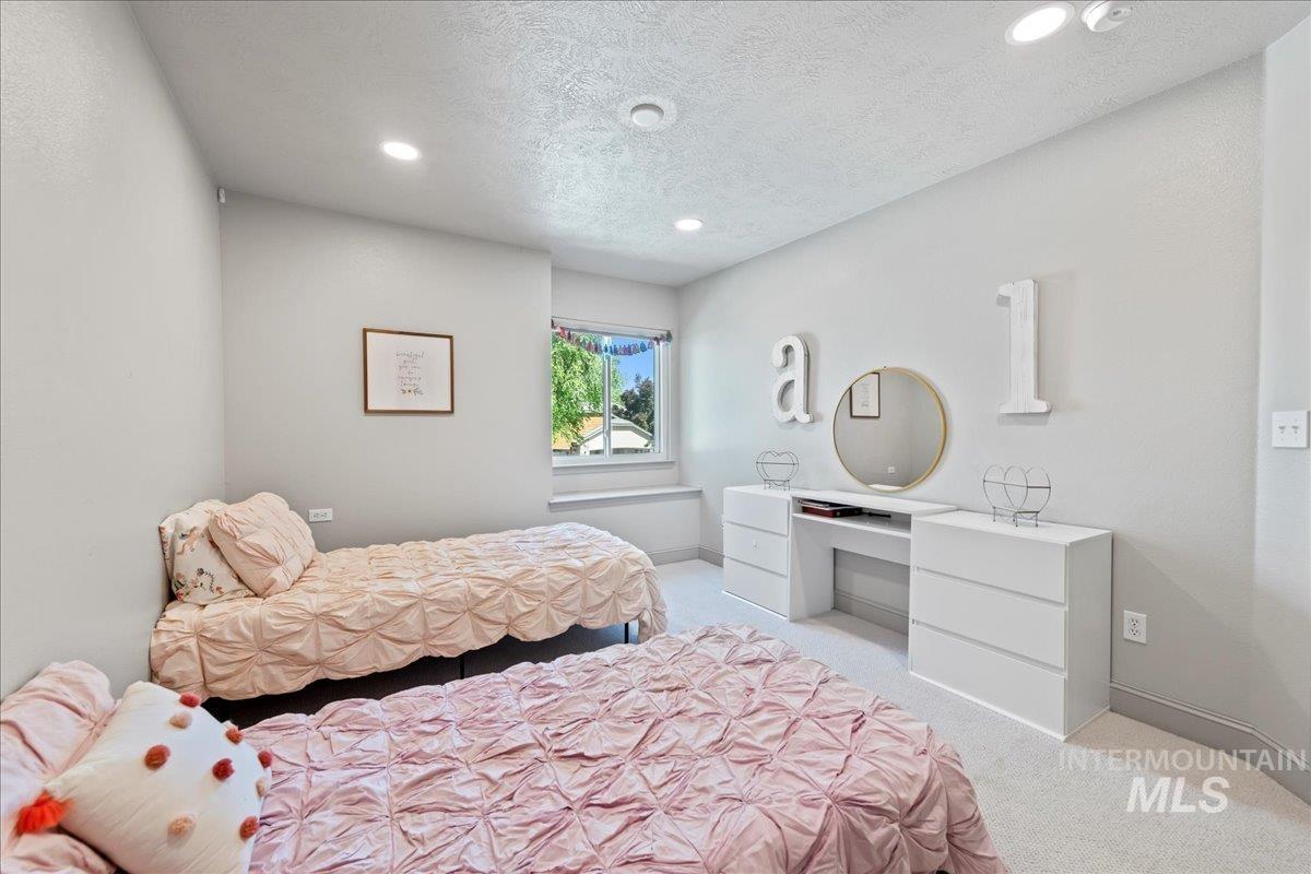 Bedroom featuring light carpet, recessed lighting, and a textured ceiling